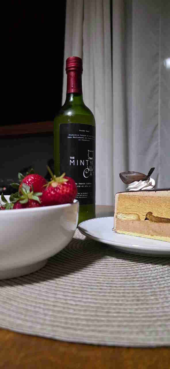 The Minty Cat bottle served with cake and strawberries